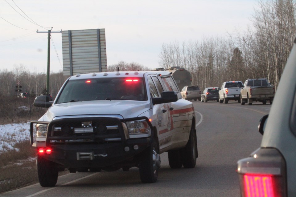 A Lac La Biche County  rapid response fire services truck with lights and sirens activated moves past traffic at a Wednesday crash near railway tracks on Highway 881 north of Lac La Biche.