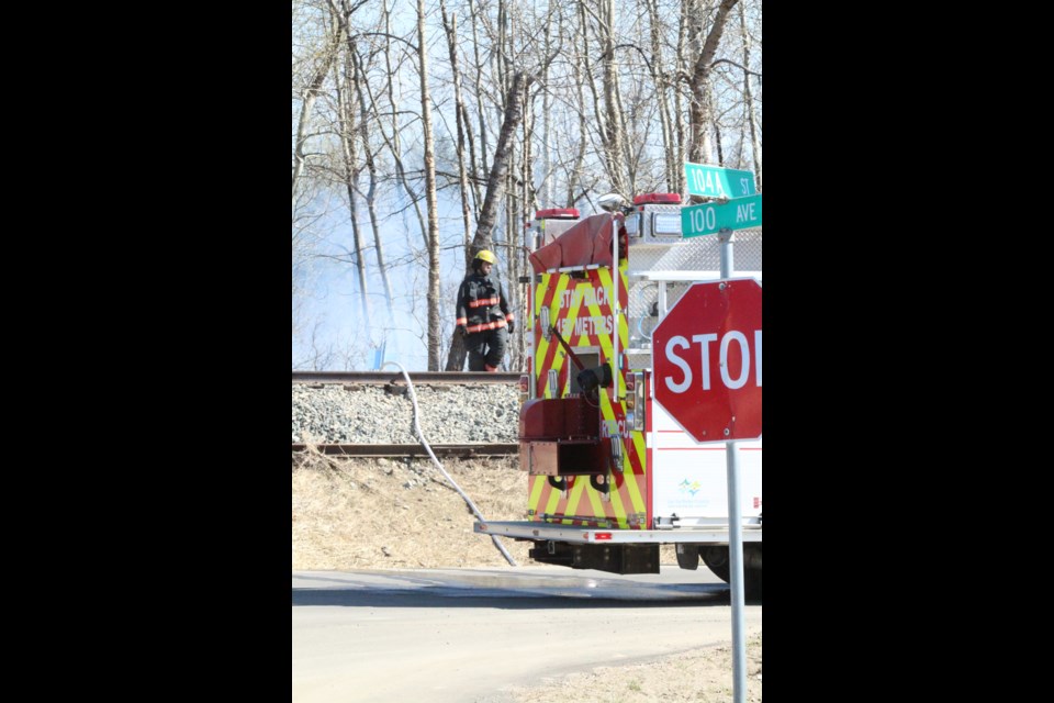 A Lac La Biche County firefighter walks to the scene of a 'tent city' fire on Thursday afternoon.
