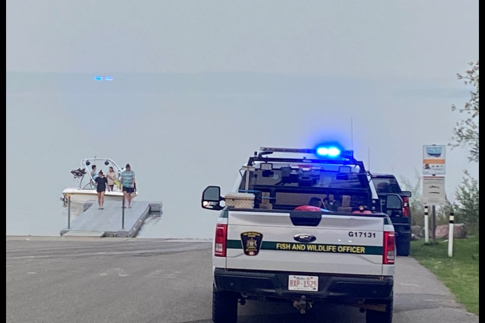 A Fish and Wildlife vehicle and an officer remains at the Young's Beach boat launch on Sunday evening after emergency crews responded to a call.