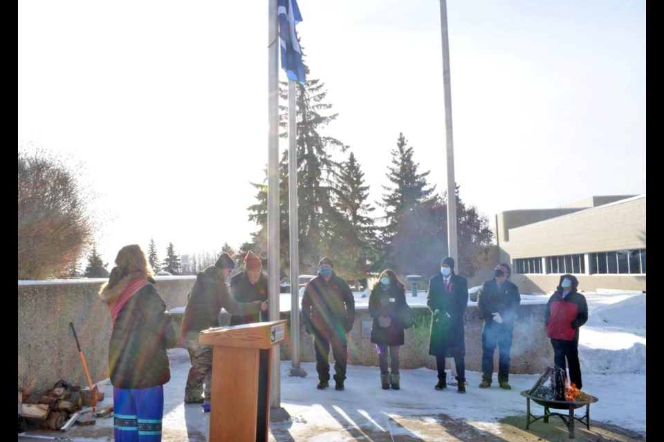 The Metis flag is raised into a chilly but sunny sky on Thursday at Portage College. Image Bianca Mazziotti.