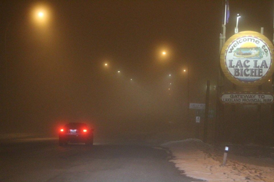 An early morning motorist drives into the Lac La Biche hamlet with barely any features of the Main Street visible under the blanket of fog.