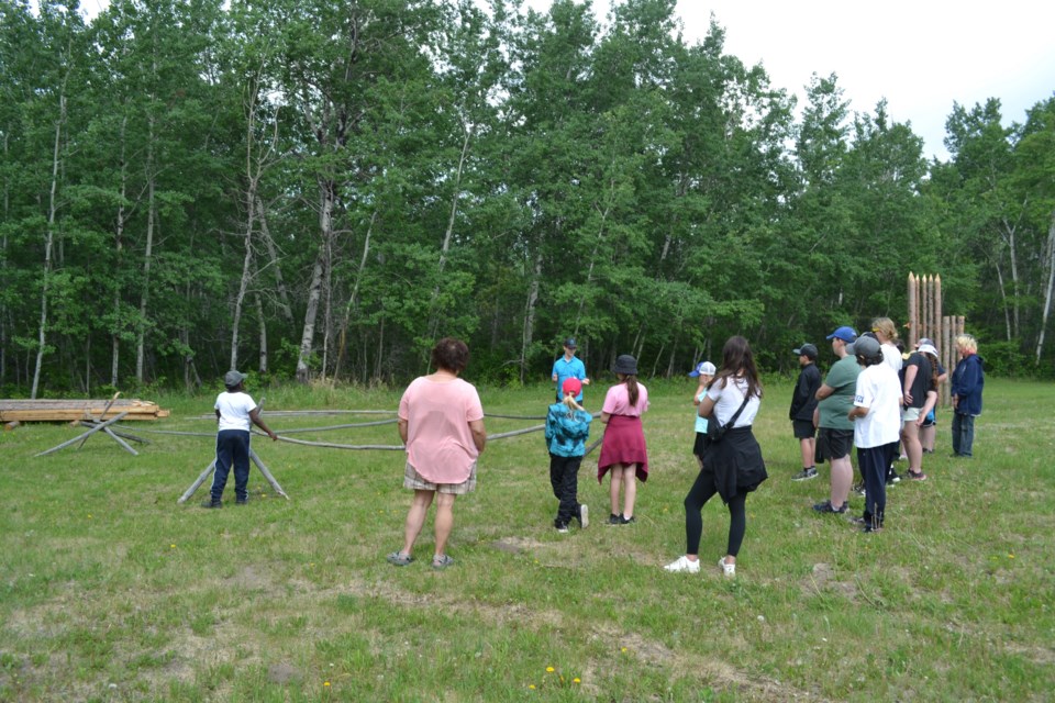 Down the trail at the Fort George site, interpreter Levi Power explains the working of a buffalo pound, used to capture buffalo for meat and hides during the fur trade era, to Grade 4 to 6 students from Dewberry School and their supervisors during their May 31 school visit.