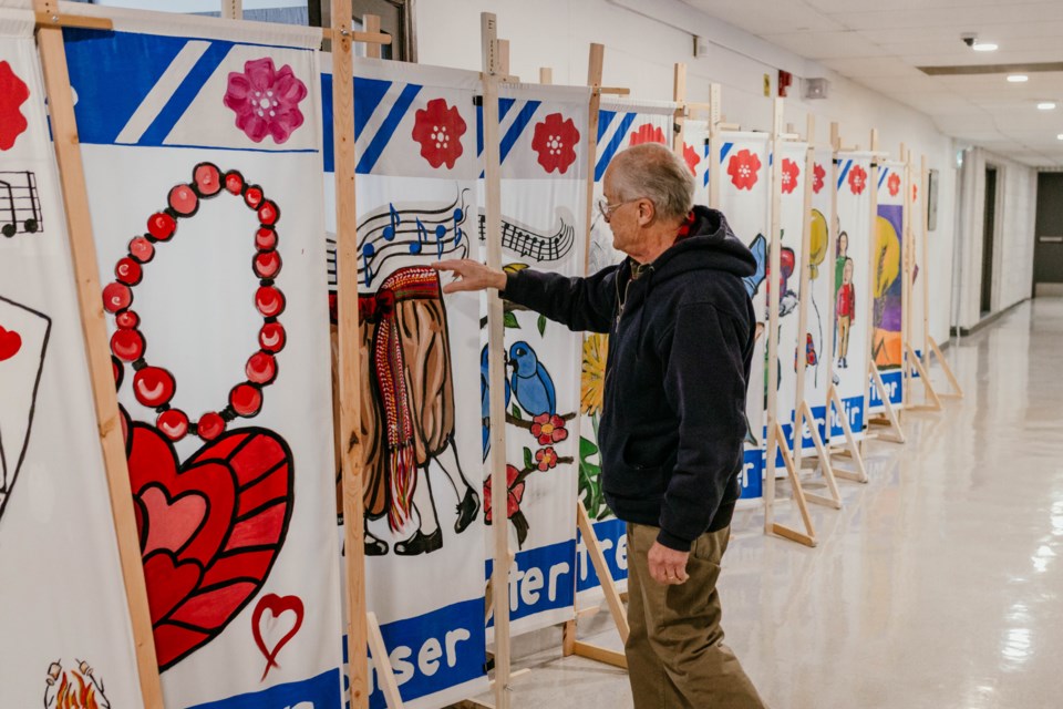 Herman Poulin shows the unique, colourful banners that have been created by members of the St. Paul francophone community.