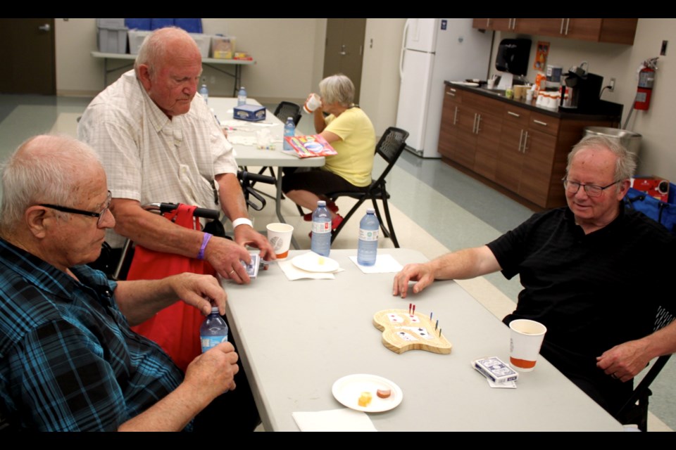 If weeknights are a little quiet ... go to the library.  That's what an on-going social program is encouraging by getting residents to drop into the library for some fun, games and friendly conversation? On Tuesday a dozen area were at the weekly games night, held from 6:30 – 9:00 at the Stuart MacPherson Public Library. The night is sponsored by FCSS and includes free coffee, tea, and snacks. Pictured — Steve Chorzempa, Charlie Ryall, and Kevin Peterson didn't move too far from the coffee pot as they put their crib skills to the test during a friendly matchup in the library staff room.

