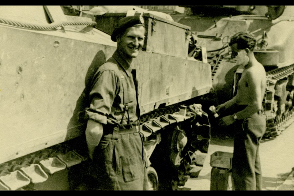 Glen Meyer stands with a tank group member who is shaving beside their tank in Holland in 1945