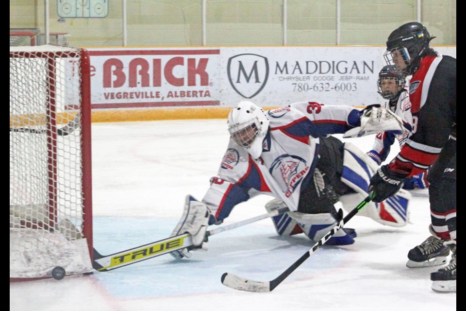 U-18 Clippers goalie Jarrik Berard dives to keep a Wranglers shot from going into the net during last Sunday's game in Vegreville.