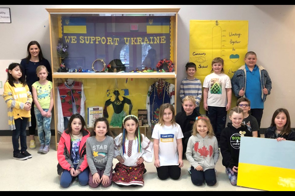 The Grade 3 class at Glendon School  is pictured in front of a display created in support of Ukraine.