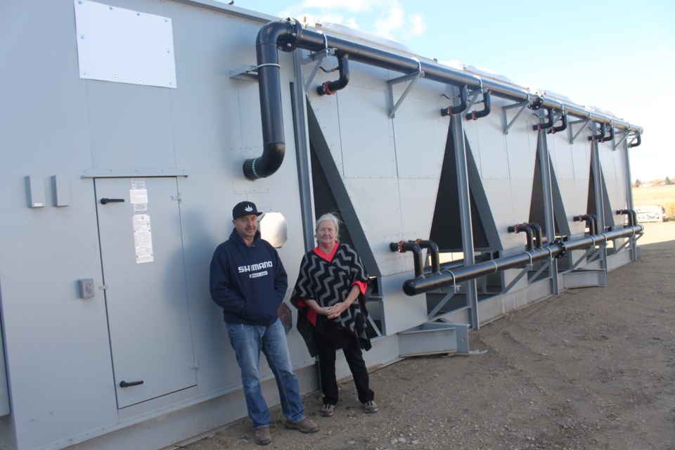 Dave Doonanco and Joanne Penner of Central Prairie Pharmaceuticals stand beside a massive chiller that will remove condensation from growing rooms in the new facility in St. Pau’s industrial subdivision. Clare Gauvreau photo.