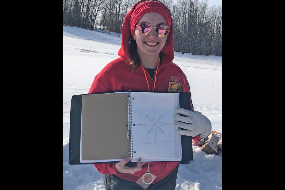 Hannah Bergeron with the map of the compass the Junior Forest Wardens would transform into snow art 200 feet wide.     Submitted