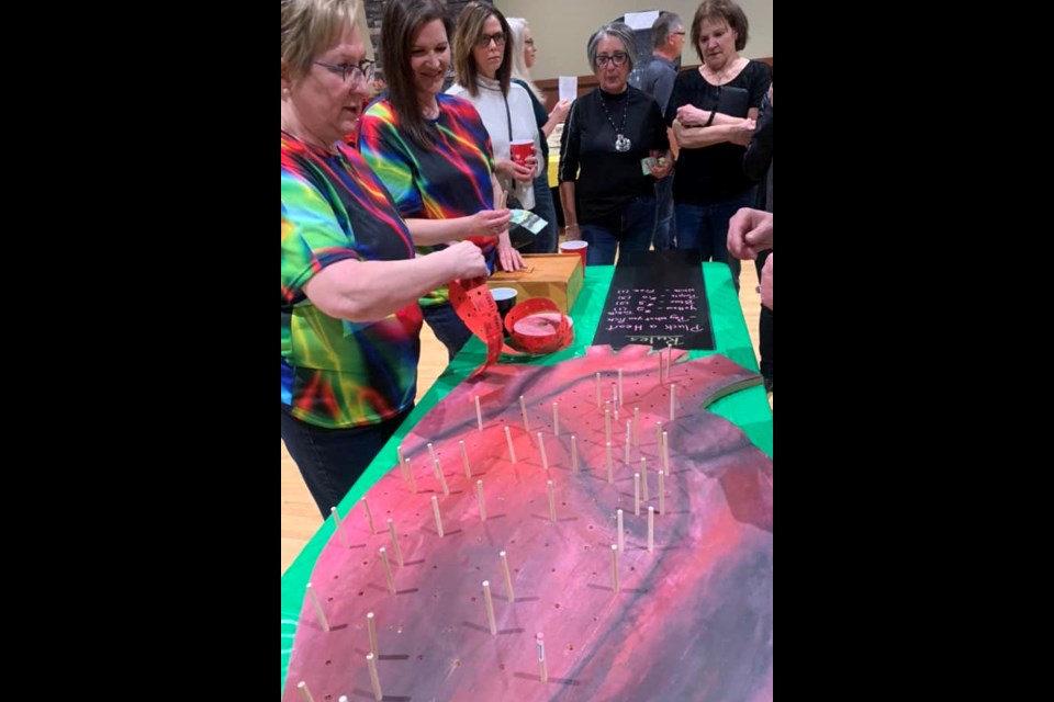 They called this game 'pluck a heart'. It was a way to purchase raffle tickets and donate various dollar amounts to the foundation. The night raised enough money to pay for $77,000 lighting infrastructure in the W. J. Cadzow Hopsital's operating room.