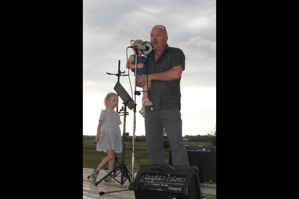 MLA David Hanson had some help from his granddaughters as he welcomed visitors to Elk Point Heritage Days stage show, just minutes before the skies opened up to shut most activities down for well over an hour as everyone scrambled for cover.