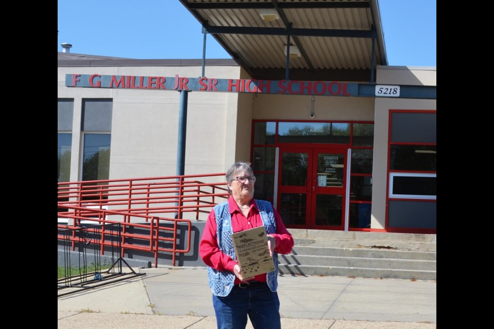 Back where it all began, Sherry Milholland displays a copy of ‘Reflections – A History of Elk Point and District’ that she and fellow founding members of the Elk Point Historical Society created, following the Sept. 4, 1975 meeting at F. G. Miller High School that launched the society. 
