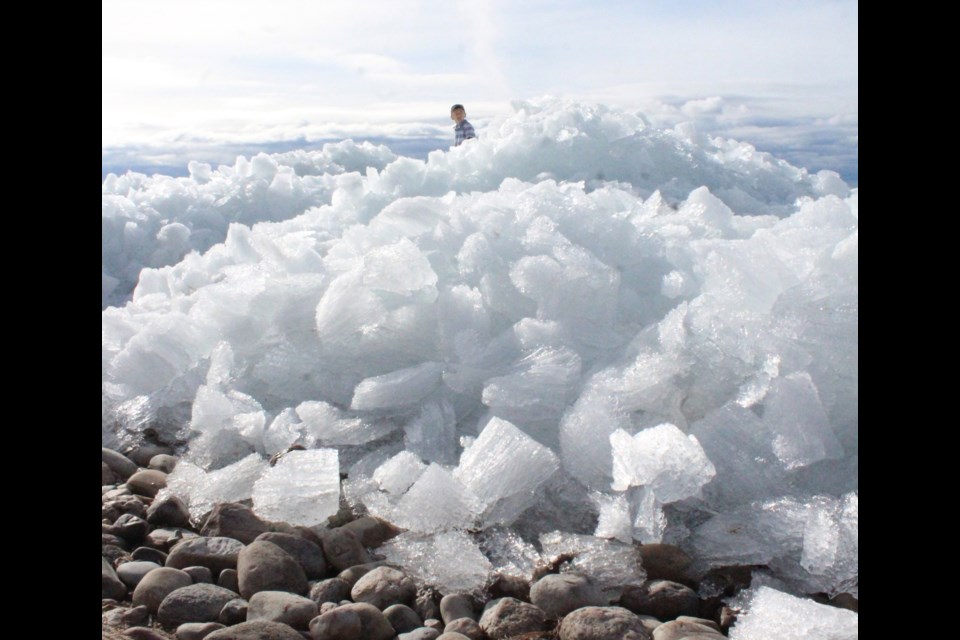 A youngster's head is visible above mounds of crushed ice stacked on the Lac La Biche lakeshore. The unique natural feature has been attracting attention for the last two days. 