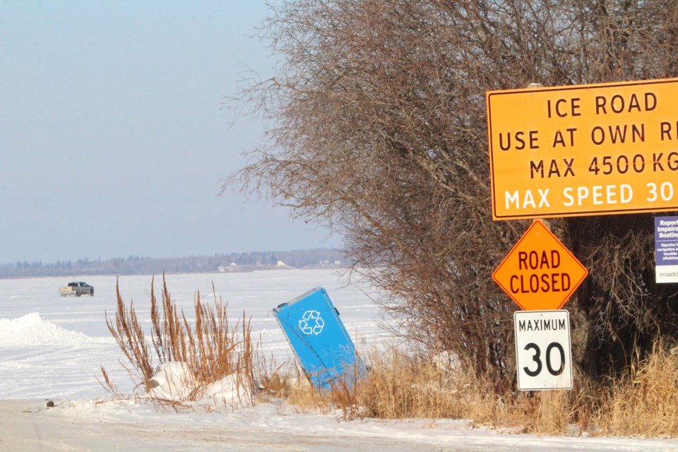 A motorist goes off the graded road and into shallow snow after getting onto the frozen surface of Lac La Biche lake at Maccagno Point. Municipal officials have recently closed the ice road due to a large crack on the ice surface.