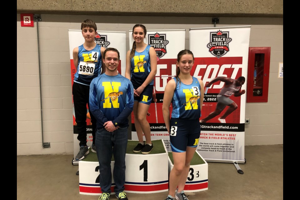NEAT Coach Matthew Hurtubise stands with NEAT athletes Adam Swiegocki, Porscha Tomlinson and Maya Swiegocki during the Alberta Indoor Track and Field Championships on March 5.