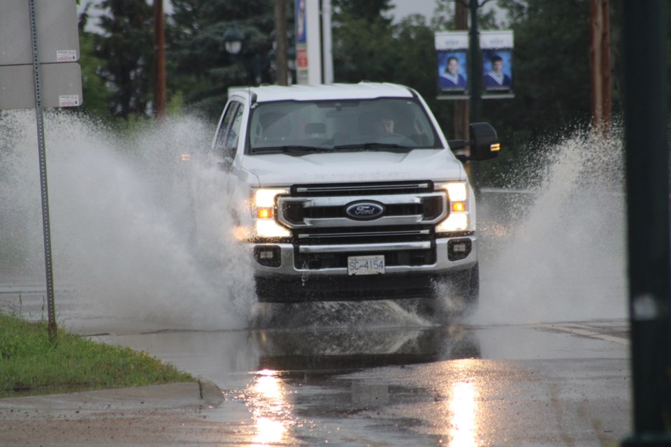 A vehicle splashes through a water-filled low-spot on Beaver Hill Road near Home Hardware after an afternoon downpour. The Lac La Biche region has seen significant precipitation amounts over the last two weeks — along with hot temperatures and active lightning storms. The forecast for the rest of the week looks like it will be more wet than dry for the Lakeland area. See the forecast at https://www.lakelandtoday.ca/weather