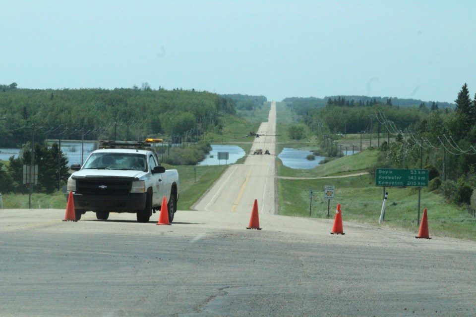 Pylons and an Alberta Transportation truck block a portion of Highwy 55 west of the hamlet of Plamondon on Friday afternoon due to flooding. By Friday night, the roadway was back open.  Highway closure notices can be found on 511.ca
Image: Rob McKinley