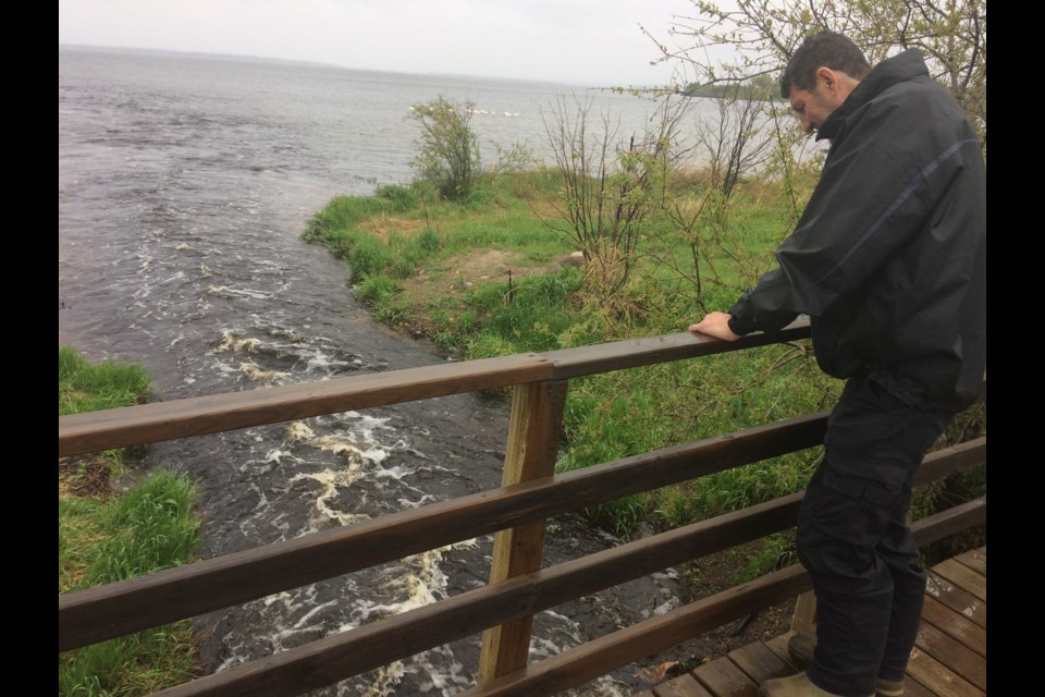 Lac La Biche County Mayor Omer Moghrabi looks at the water rushing into Lac La Biche Lake from the southern intake along Nashim Drive. The mayor says the area has always been a low-lying flood plain, but said the week of steady rainfall has increased the water levels.
