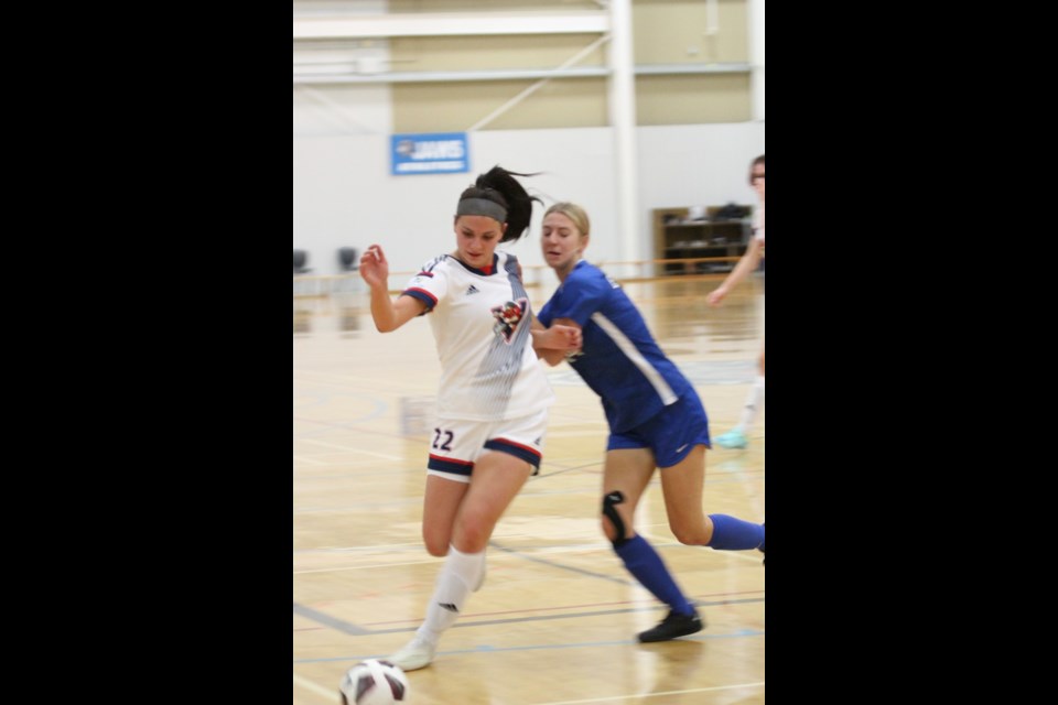 Portage's Lexis Roy stays with the ball despite some body contact from King's University's Damaris Hodges.