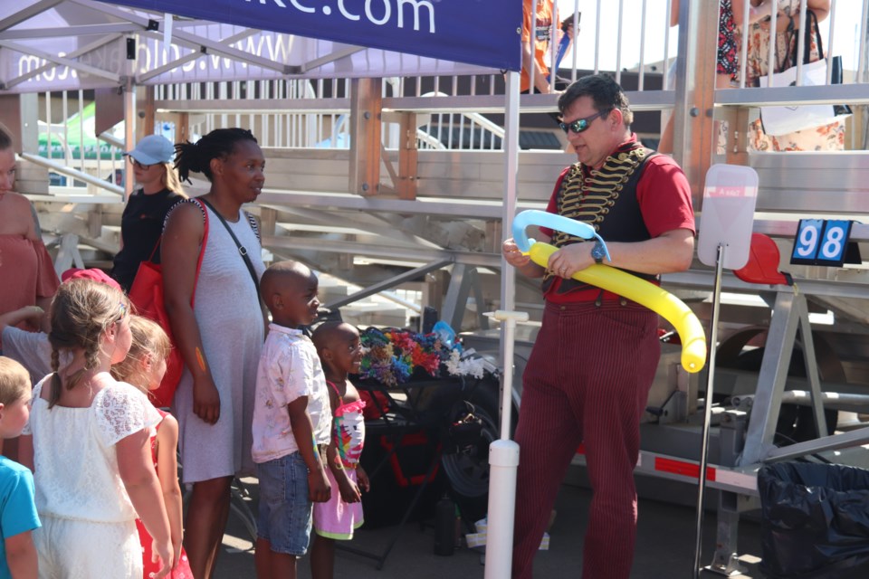 Families lined up to get their hands on a balloon animal or sword. 