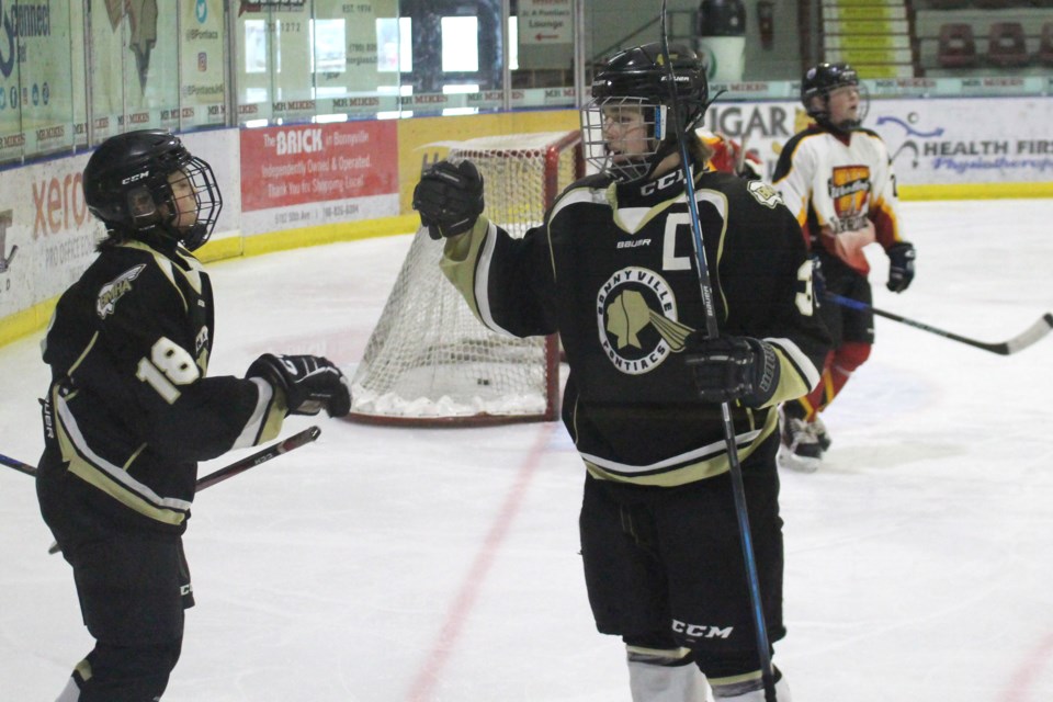 The U15 Pontiacs' team captain fist bumps Colby Rudolph, #18, after tucking the puck into the Thorsby Thunder's net.