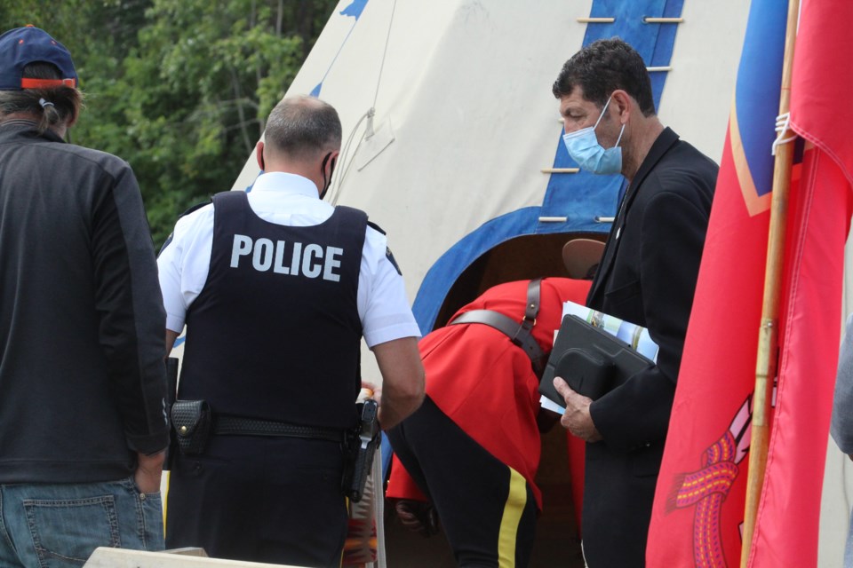 Lac La Biche Mayor Omer Moghrabi waits to enter the tipi where a ceremonial smudging and blessing of the RCMP eagle feather took place.    Image Rob McKinley