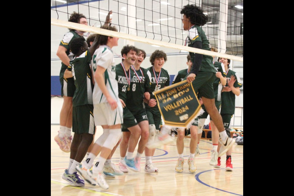 Fort McMurray's Holy Trinity HIgh School Knights celebrate with the zone banner after beating the J.A. Williams boys team in three sets.