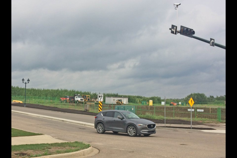 With construction equipment in the background, a vehicle turns at the intersection of Beaver Hill Road and 91 Avenue. The site is the proposed location of the first Tim Hortons in Lac La Biche.
