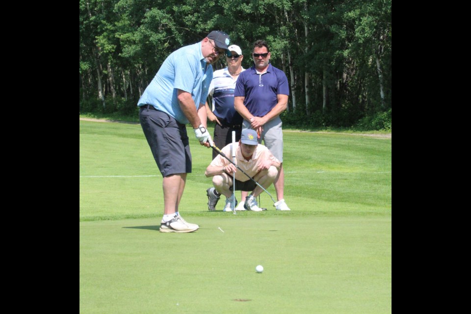 Jeff Dechaine's group watches intently as he drains this one from about 15 feet. Scores weren't the main goal of the golf day, which raised $15,000 for Rotary charitiies.