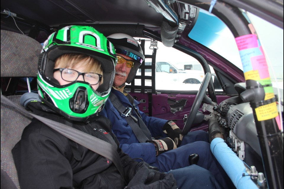 Staples behind the wheel of his ice racing Neon with one of several ‘passengers’ who took part in the fundraising ride-along during last year’s races.  The ride-along program will roll again this year.