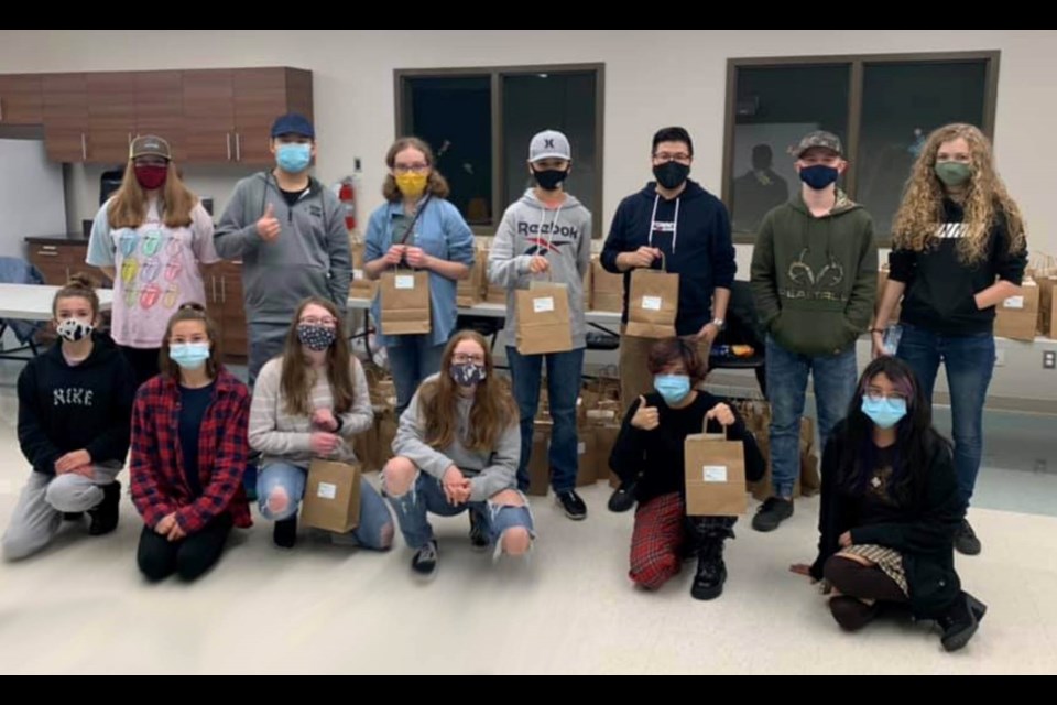 The teens with a sample of the Christmas-themed packs for community families.