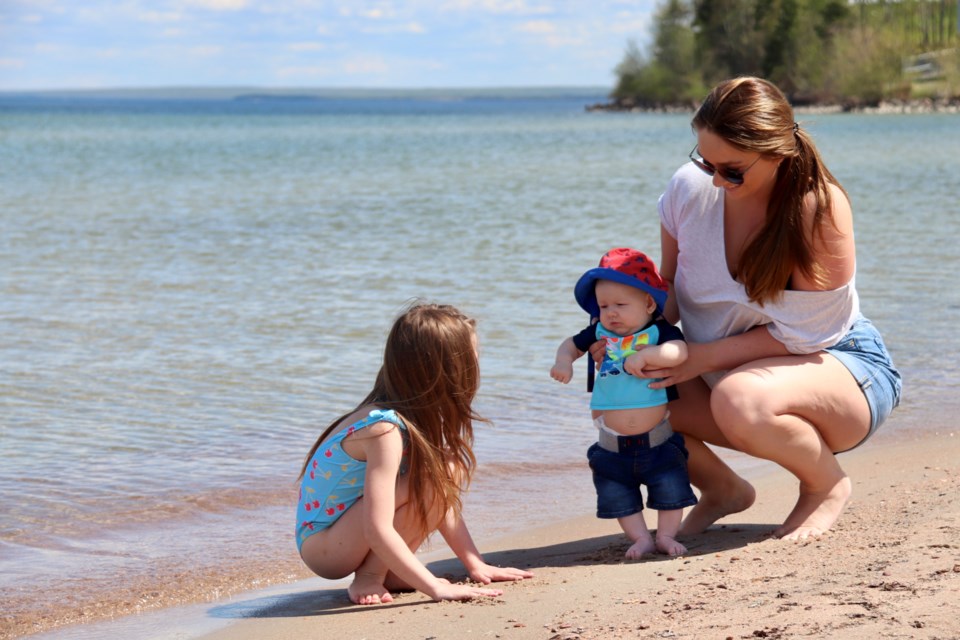 Families flocked to Cold Lake's shores over the weekend to soak up some sun. Here, Shania Frost and her six-year-old daughter Hannah and three-month-old son Axel enjoy the warm weather at Kinosoo Beach. Meagan MacEachern Photo