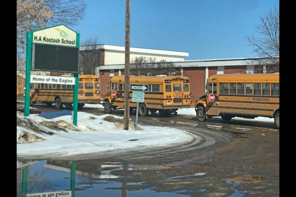 School buses outside the H.A. Kotash School in Smoky Lake on Friday afternoon after a day that began with a community lockdown.