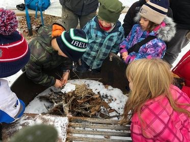 Under the supervision of leader Sandra Majowski, the Boreal Explorers work on building a fire from flint.     Supplied