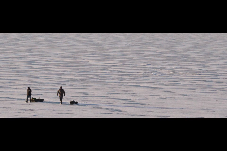 Two fisher-folk make their way back to shore in an winter-landscape after a morning of fishing on Lac La Biche lake recently.