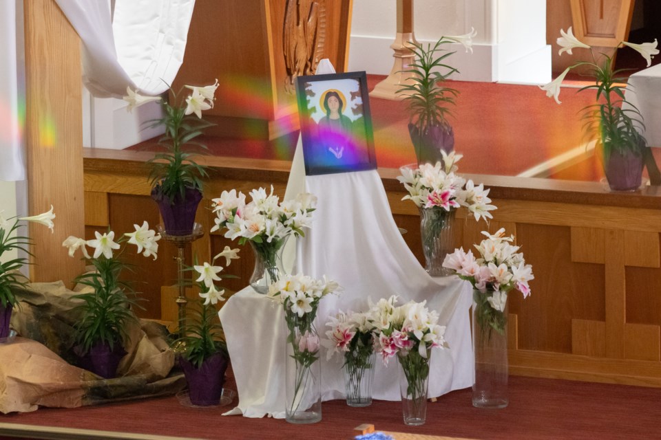 The image of St. Kateri Tekakwitha and a table with vases where parishioners later placed lilies during the mass.