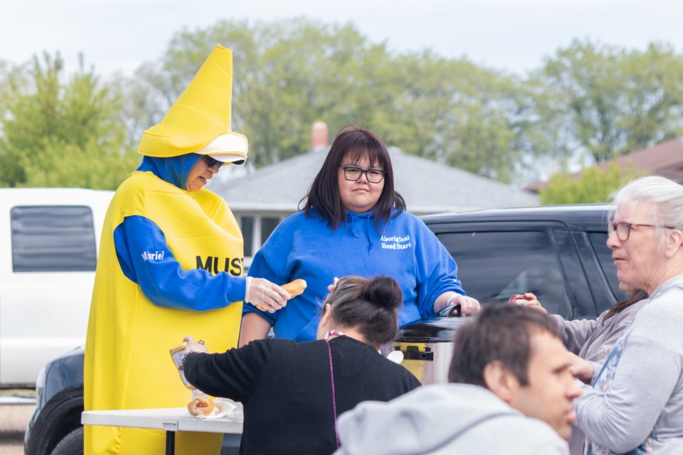 Staff at Aboriginal Head Start serves up hotdogs to members of the community.