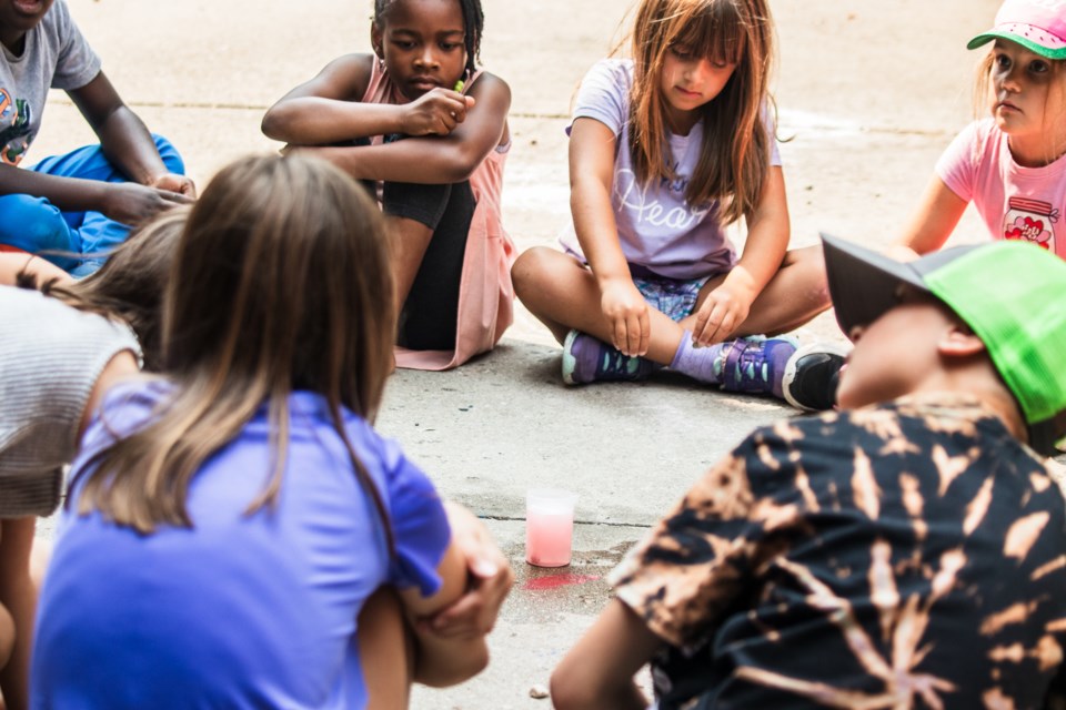 Youth observe a chemical reaction during a science activity as part of the weekly day camps hosted by the ACFA Régionale de Saint-Paul.