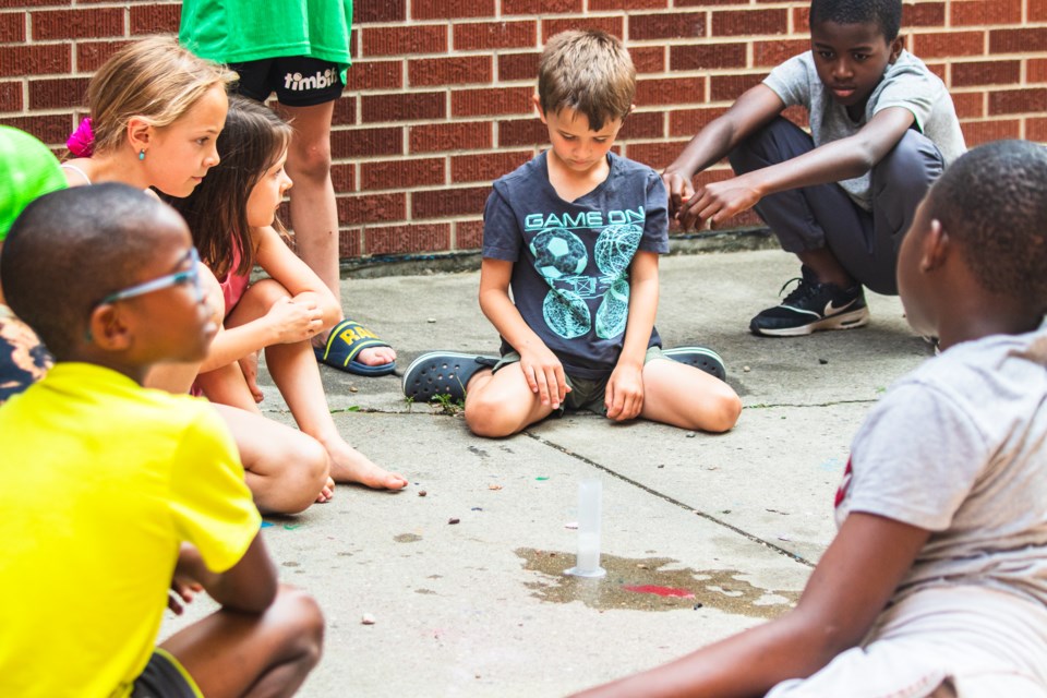 Youth observe a chemical reaction during a science activity as part of the weekly day camps hosted by the ACFA Régionale de Saint-Paul.