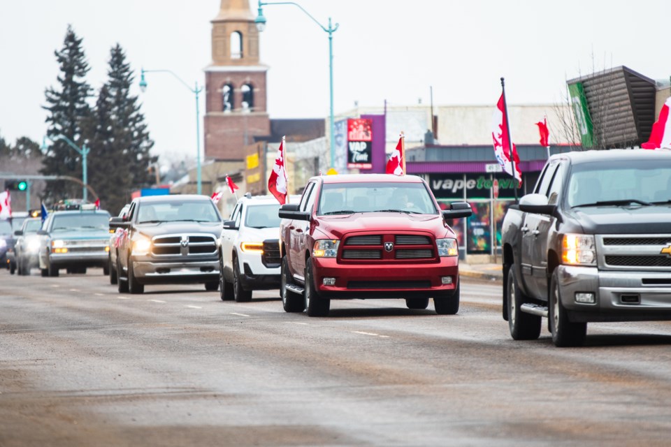 Protesters against carbon tax drive through the main street in St. Paul on April 7.