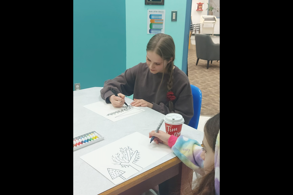 Caydence Bohn (left), the library's winter program coordinator, and Felicity Robinson (right) during the library's Watercolor Winter Tree art event on Jan. 13.
