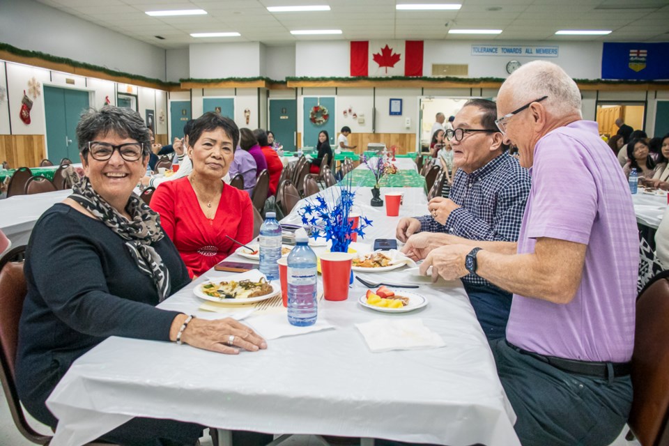 Town of St. Paul Mayor Maureen Miller (left) visits with residents during the St. Paul Filipino association's Christmas Party on Dec. 16.