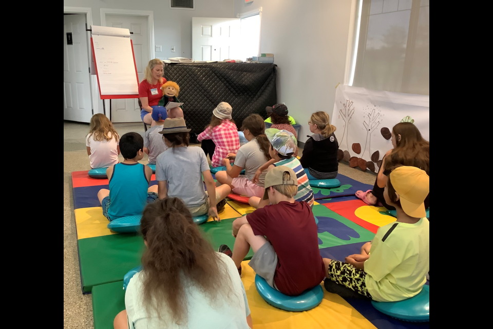 Director Lynn Smid reads to children during Camp Sunshine, a bereavement camp for children to help them navigate their grief. 