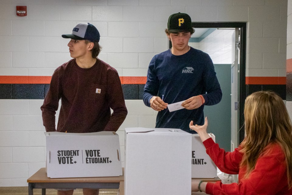 SPRHS student Tessa Bauer (right) guides Josh Siewiertoka (left) and Ty Lafrance as they cast their ballot.
