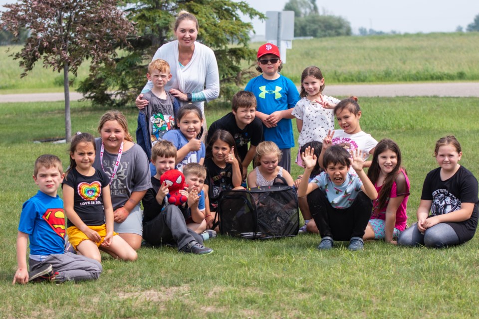 Glen Avon teacher Kyla Reid is pictured with her students on June 16, prior to releasing the butterflies inside the black container.