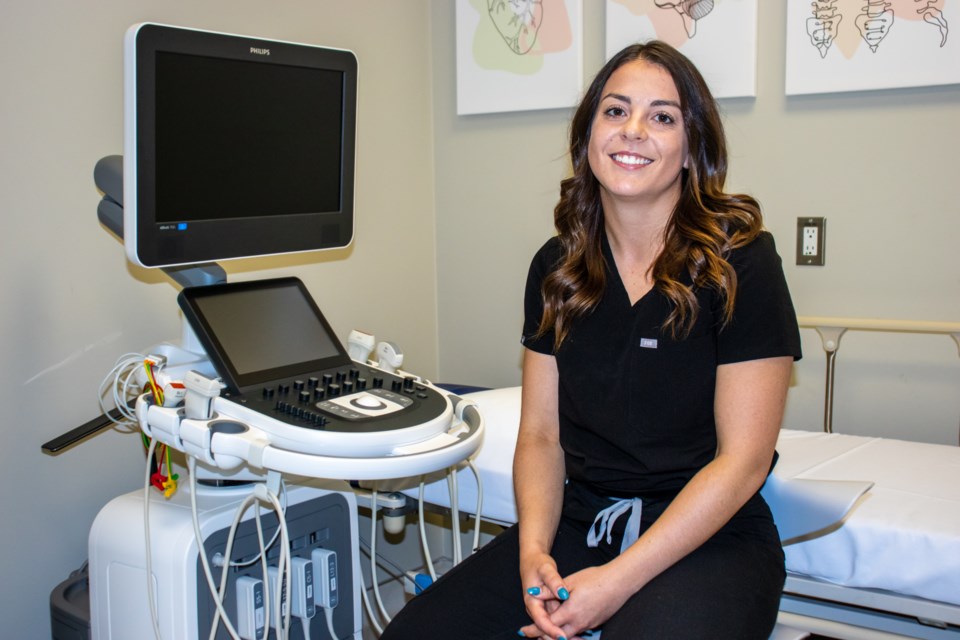 Amy Bespalko sits on her clinic, with the sonography equipment on the background.