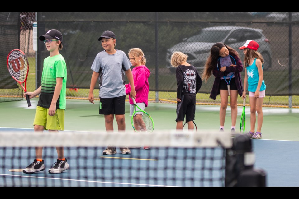 Youths have fun with tennis camp despite the drizzling rain on July 28.