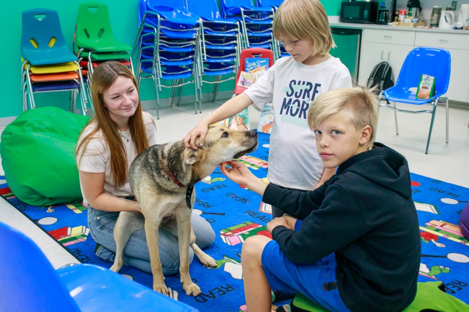 McKenna Watt (left), and brothers Kade (middle) and Easton Rivard plays with Kodi.
