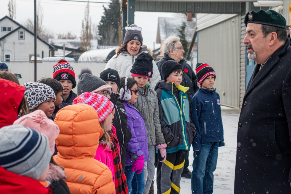 Peter Bednarchuk (right) welcomes students from St. Paul Elementary School during the flag-raising ceremony for the annual poppy campaign in St. Paul on Oct. 27.