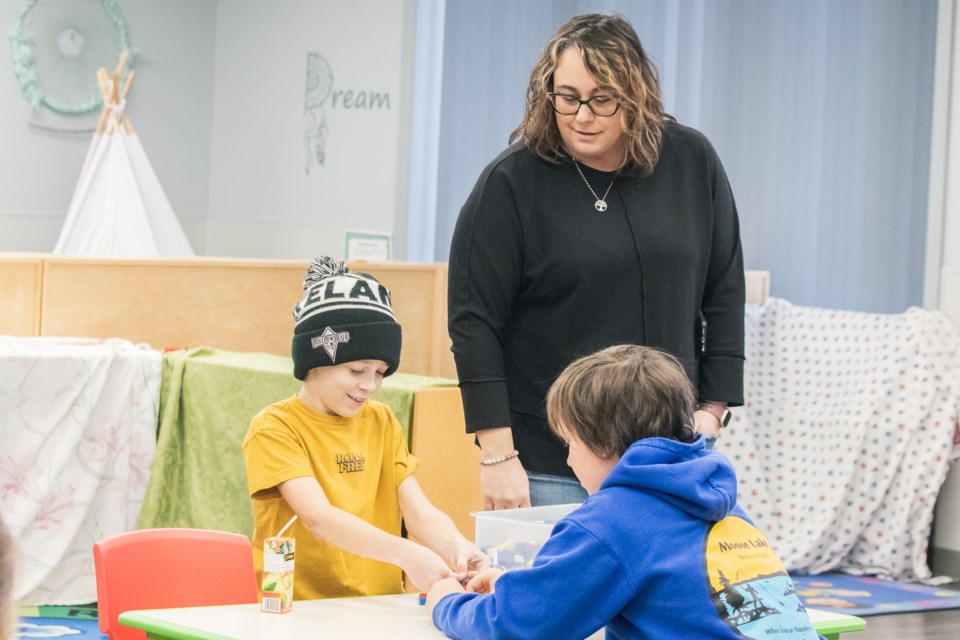 Leah Burton, Family Educator Programmer Assistant at Lakeland Family Resource Network, inspects Jax Sinclair's (left) and Bjorn Johnsen's work during Lakeland FRN's Youth LEGO Challenge on Feb. 6.
